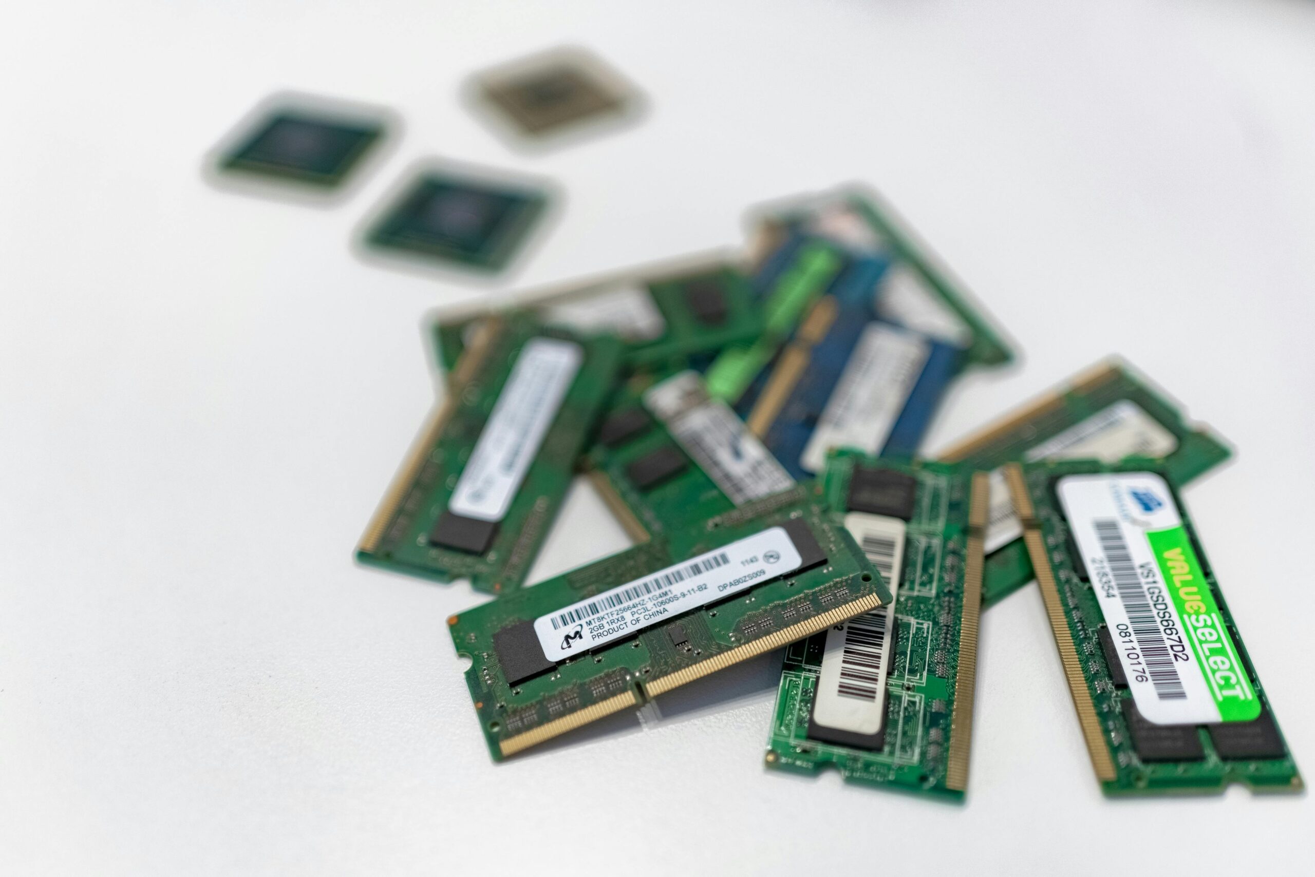 Assorted RAM modules scattered on a white surface, showcasing technology components.
